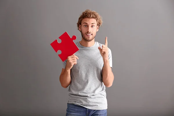 Young Man Piece Jigsaw Puzzle Raised Index Finger Grey Background — Stock Photo, Image