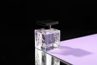 Karanlık arka planda bir şişe parfüm.