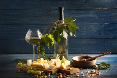 Cam ve peynir ve renk ahşap masa üzerinde olgunlaşmış üzümler beyaz şarap şişe