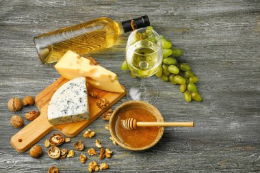 Cam ve aperatifler ve ahşap masa üzerinde olgunlaşmış üzümler beyaz şarap şişe