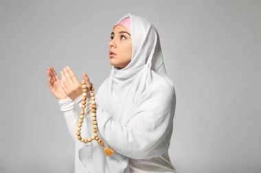 Işık arka plan üzerinde dua genç Müslüman kadın