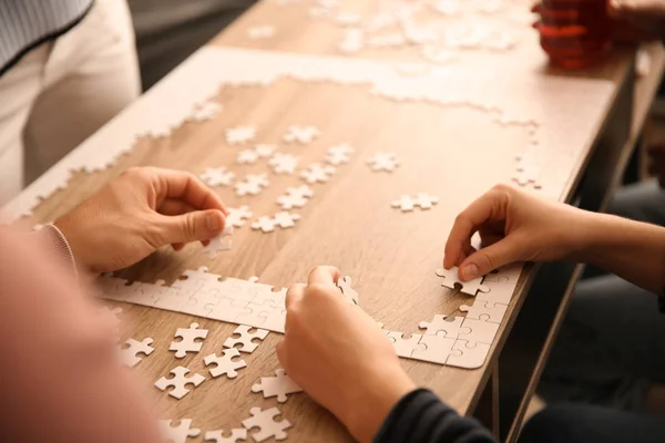 Group People Assembling Puzzle Wooden Table — Stock Photo, Image