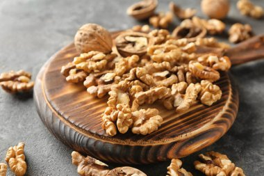 Gri masada lezzetli ceviz ile ahşap tahta