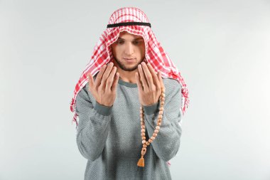 Genç Müslüman adam ışık arka plan üzerinde dua