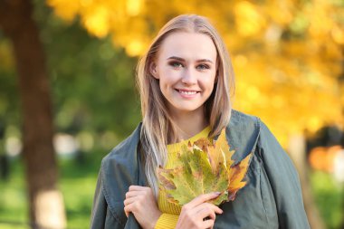 Parkta güzel genç kadın ile sonbahar yaprakları
