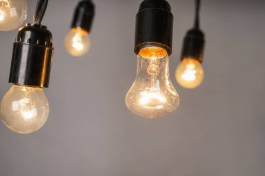 Gri arka plan üzerinde parlayan ışık Ampüller