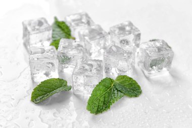Buz küpleri ve beyaz zemin üzerine nane yaprakları