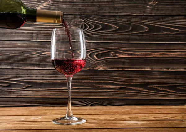Şarap şişe masanın üzerinde cam içine dökme