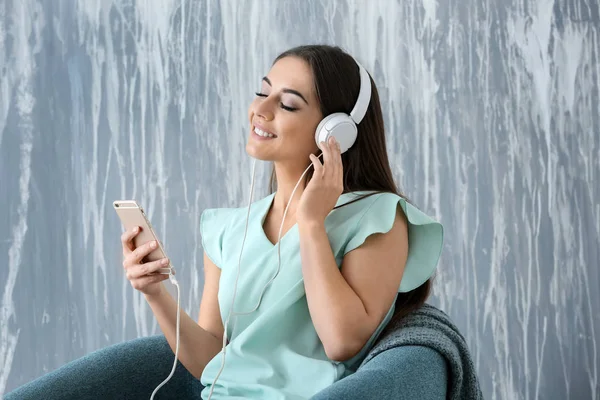 Beautiful Woman Listening Music While Sitting Armchair Grey Wall — Stock Photo, Image