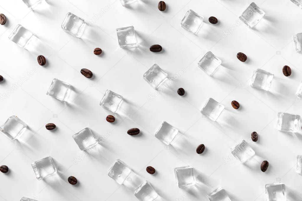 Ice cubes and coffee beans on white background