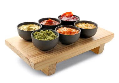 Beyaz arka plan üzerinde kase lezzetli soslar ile ahşap stand