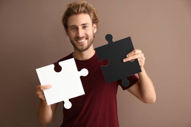 Parçalı bulmaca renk arka plan üzerinde parçaları ile genç adam