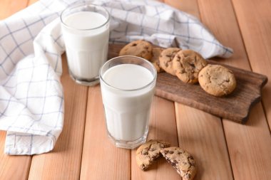 Lezzetli süt ve kurabiye ahşap masa üzerinde gözlük