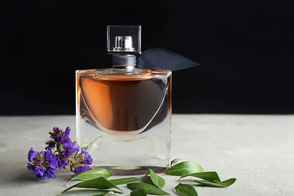 Garrafa Perfume Com Flores Mesa Cinza — Fotografia de Stock