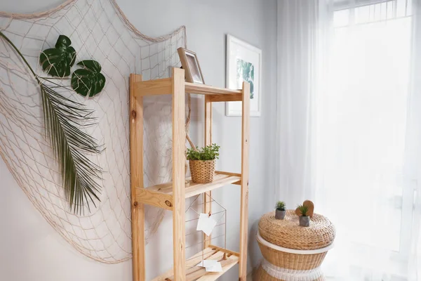 Shelving unit with green plant and decor in room