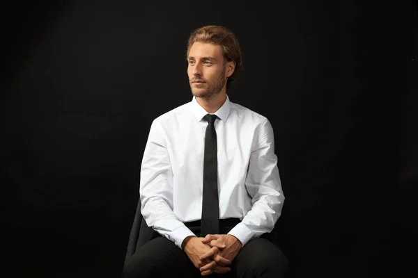 黒の背景に座っている成功した実業家 — ストック写真