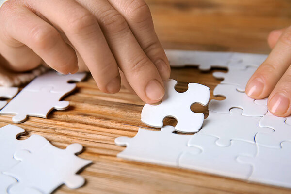 Woman doing puzzle at table, closeup