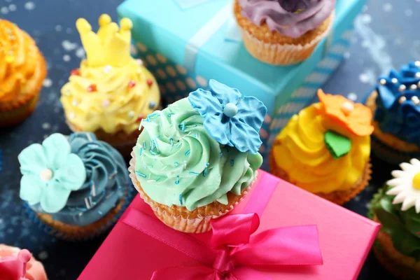 Leckere Cupcakes Und Geburtstagsgeschenke Auf Farbigem Hintergrund — Stockfoto