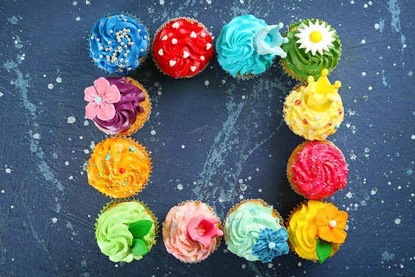 stock image Frame made of tasty cupcakes on color background