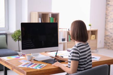 Güzel genç tasarımcı ofiste çalışıyor.