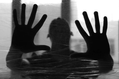 Streç film kapalı, arkasındaki adam siyah beyaz tonlu silüeti