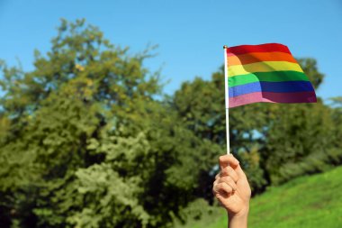 Gökkuşağı Lgbt bayrağı açık havada tutan kadın