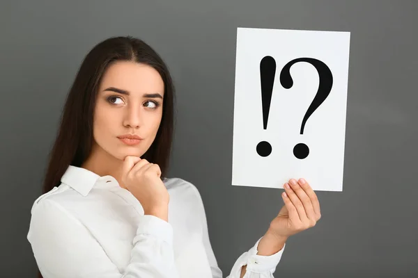 Nachdenkliche Junge Frau Mit Einem Blatt Papier Mit Ausrufezeichen Und — Stockfoto