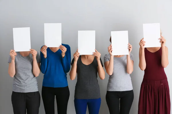 Mujeres Jóvenes Escondiendo Rostros Detrás Hojas Papel Blanco Sobre Fondo —  Fotos de Stock