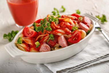 Sosis ve seramik tabak hafif masa üzerinde sos ile lezzetli makarna