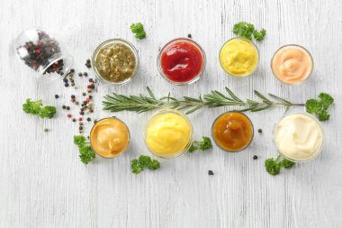 Kase ile baharat beyaz ahşap masa üzerinde farklı lezzetli soslar