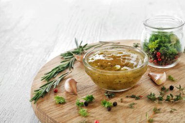 Otlar ve baharatlar ahşap tahta üzerinde kase lezzetli sos