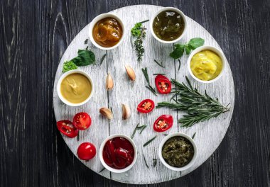 Kase ahşap masa üzerinde farklı lezzetli soslar