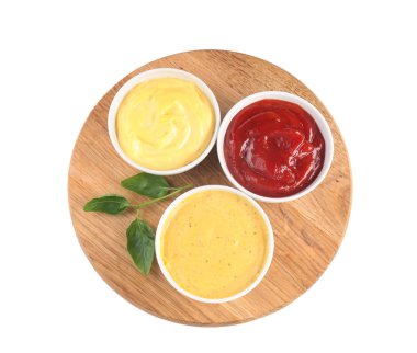 Wooden board with tasty sauces in bowls on white background clipart