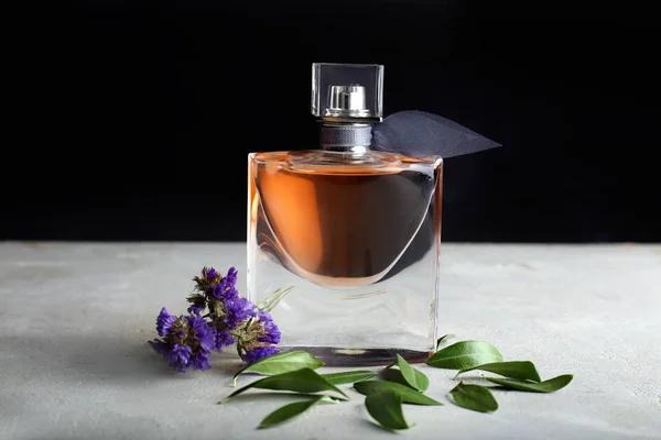 Butelek Perfum Kwiatami Stół Szary — Zdjęcie stockowe