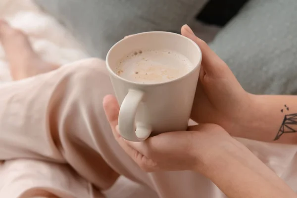 Woman drinking aromatic coffee in bed, closeup