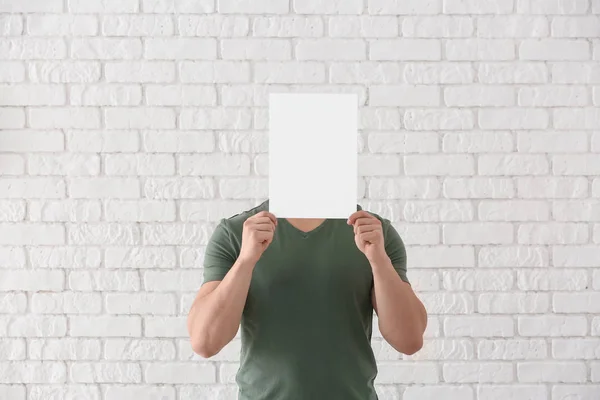 Young Man Hiding Face Blank Sheet Paper White Brick Wall — Stock Photo, Image