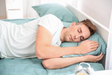 Evde yatakta uyuyan yakışıklı