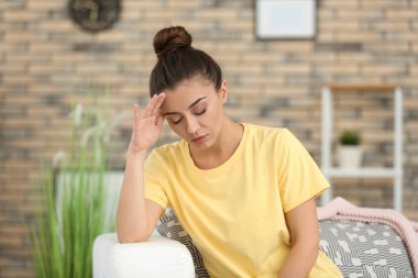 Evde baş ağrısı çeken bir kadın.