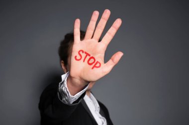 Word Stop avucunun gri arka plan üzerinde yazılı olan kadın. Yolsuzluk kavramı