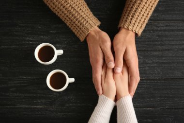 Kahve ahşap arka plan ile cups sevgi dolu genç çift