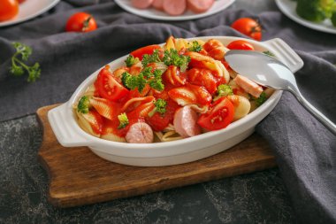 Sosis ve masada seramik tabak sos ile lezzetli makarna