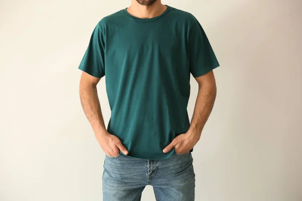 Young man in stylish t-shirt on white background