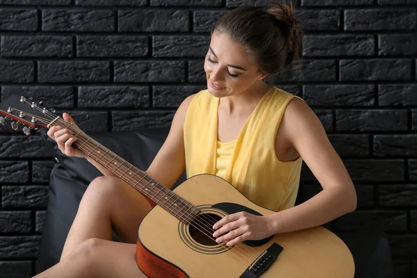 Mooie Vrouw Speelt Gitaar Buurt Van Donkere Bakstenen Muur — Stockfoto