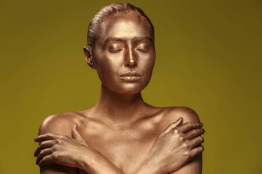 Altın boya renk arka plan karşı vücudu üzerinde olan güzel kadın