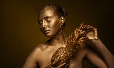 Güzel genç kadın vücudu ve ananas koyu arka plan üzerinde altın boya ile