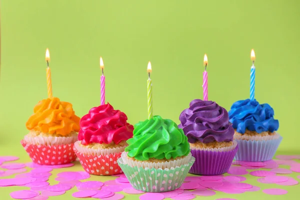 Sabrosos Cupcakes Con Velas Encendidas Sobre Fondo Color — Foto de Stock