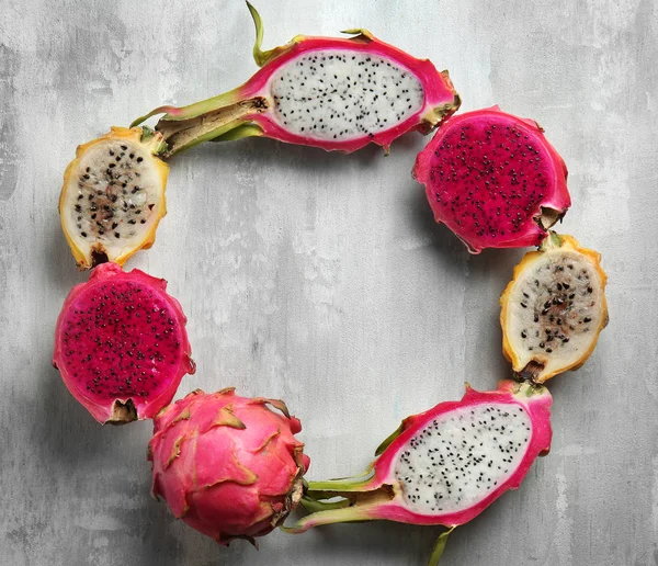 Frame made of tasty dragon fruits on grey background