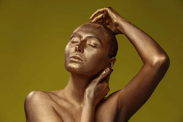 美丽的年轻女子与金色油漆在她的身体反对颜色背景 — 图库照片