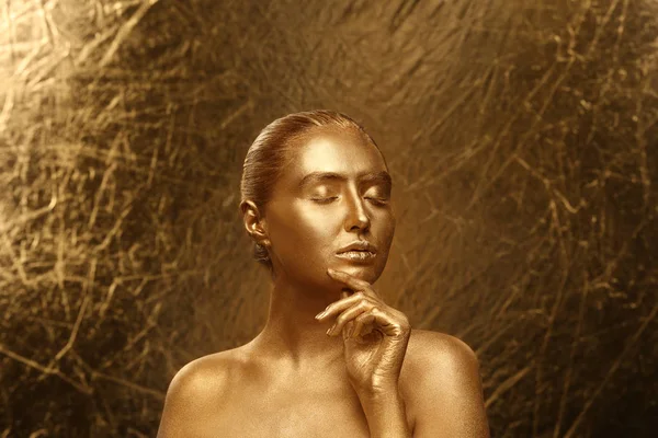 stock image Beautiful young woman with golden paint on her body against shiny color background