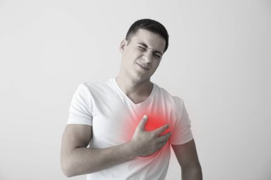 Işık arka plan üzerinde kalp krizi geçiren genç adam